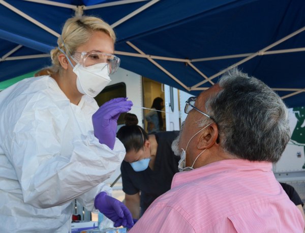 Nurse Michelle Mora administers a COVID-19 test at Alma's Flea Market Monday morning. The Kings County Pubic Health Department was expected to administer 150 tests from 8 a.m. till 2 p.m. 